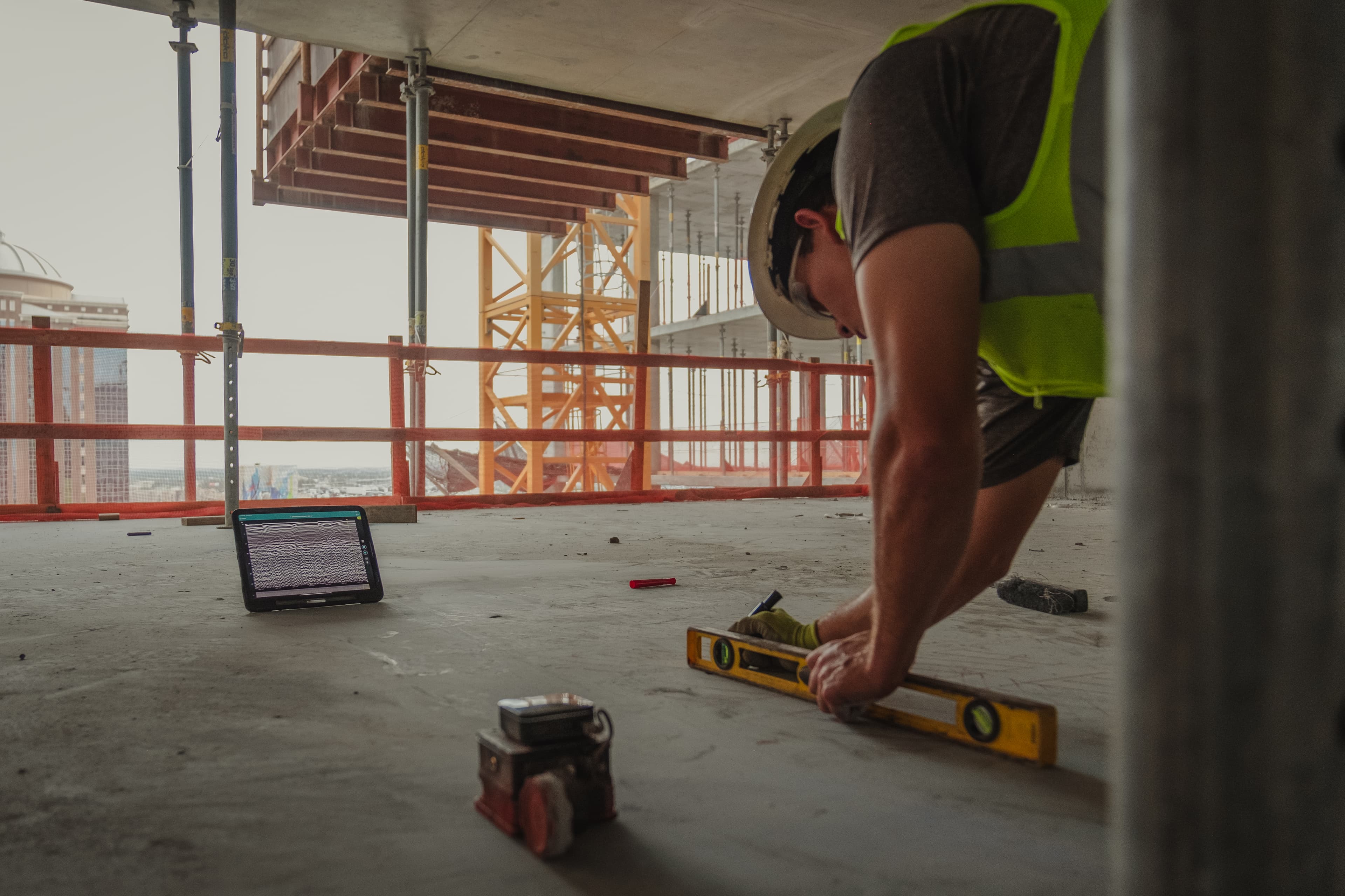 Ground penetrating radar equipment being used to scan a concrete slab on a job site.